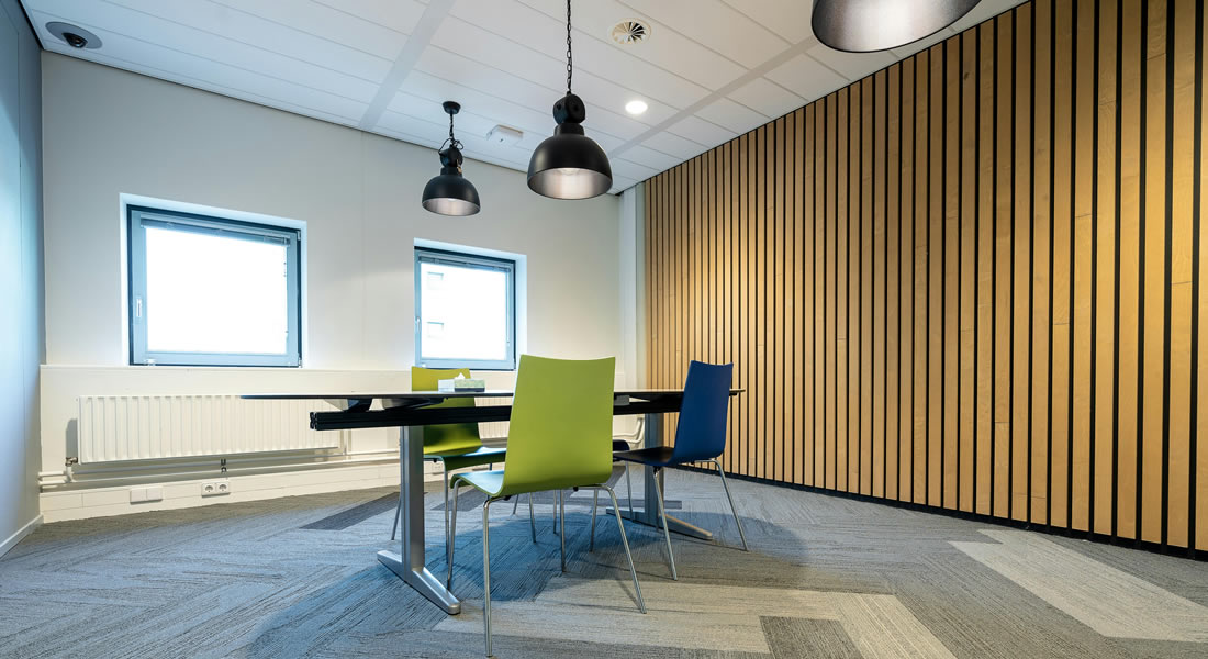 Modern meeting room with colourful chairs and contemporary lighting in a corporate workspace