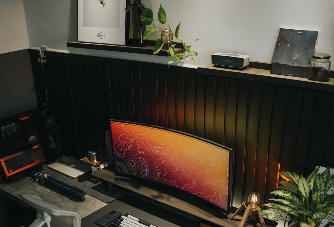 A modern workspace desk setup with a curved monitor and ergonomic accessories, representing organised behind‑the‑scenes operations that support strong member experience.