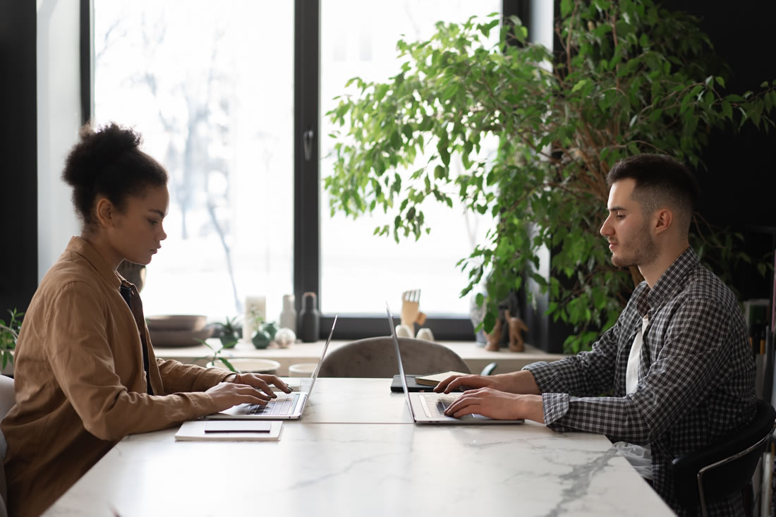 Diverse individuals working on laptops in a collaborative and modern office setting